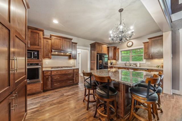 3092 Morel Rd, Columbia, TN 38401 - kitchen with stainless steel appliances, under cabinet range hood, a chandelier, a kitchen bar, and recessed lighting