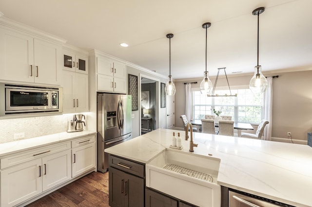1328 Reynard Dr, Gallatin, TN 37066 - kitchen with appliances with stainless steel finishes, crown molding, dark wood-style flooring, light stone counters, and hanging light fixtures
