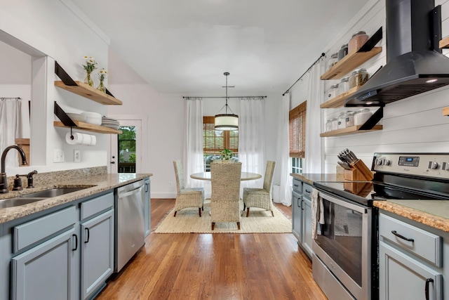 2779 Landcashire Ct, Thompsons Station, TN 37179 - kitchen featuring open shelves, stainless steel appliances, island exhaust hood, light wood-style floors, and gray cabinetry