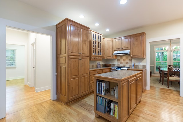 238 Wiggins Creek Dr, Sewanee, TN 37375 - kitchen with under cabinet range hood, light wood-style flooring, brown cabinets, recessed lighting, and a center island