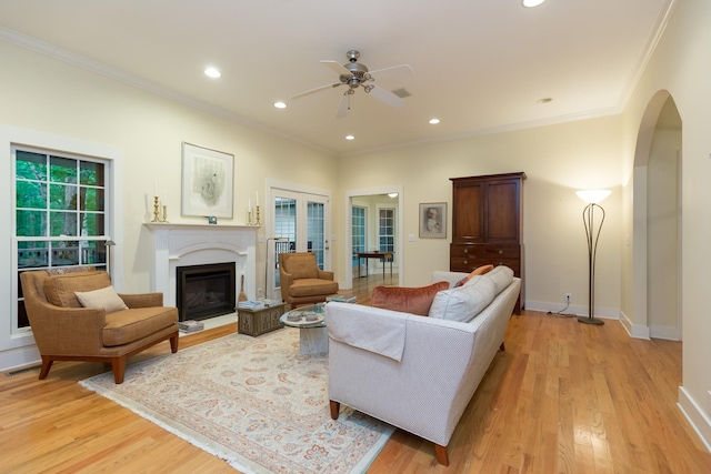 238 Wiggins Creek Dr, Sewanee, TN 37375 - living area with arched walkways, a ceiling fan, crown molding, light wood-style flooring, and a glass covered fireplace