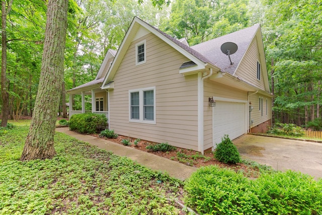 238 Wiggins Creek Dr, Sewanee, TN 37375 - view of home's exterior with concrete driveway, an attached garage, and roof with shingles