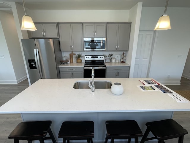 1169 Short St, Spring Hill, TN 37174 - kitchen with appliances with stainless steel finishes, gray cabinetry, dark wood finished floors, and a kitchen island with sink