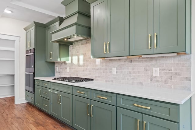 17 Peyton Pl, Columbia, TN 38401 - kitchen with green cabinetry, custom range hood, appliances with stainless steel finishes, light countertops, and dark wood finished floors