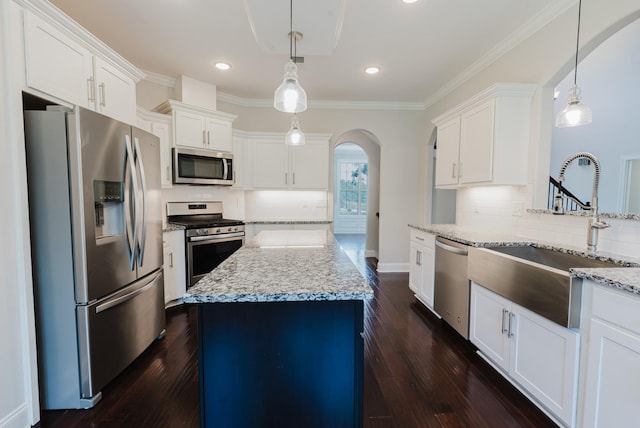 1210 Black Rd, Cunningham, TN 37052 - kitchen featuring appliances with stainless steel finishes, arched walkways, a kitchen island, backsplash, and ornamental molding