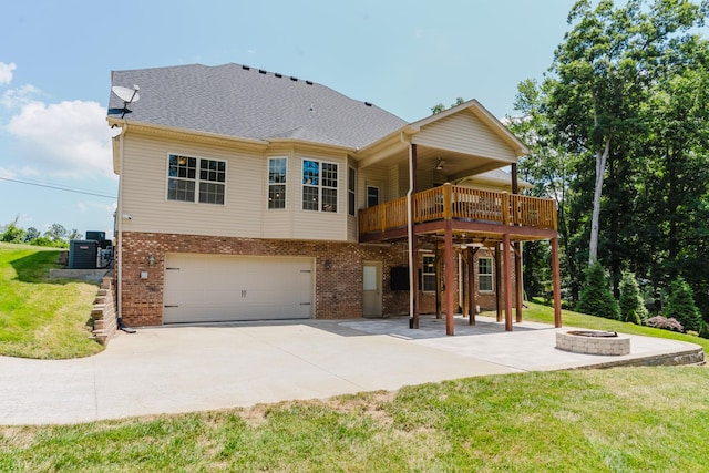 1210 Black Rd, Cunningham, TN 37052 - rear view of house with an outdoor fire pit, a garage, brick siding, and a lawn