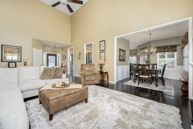 939 Central Valley Rd, Murfreesboro, TN 37129 - living area featuring a chandelier, dark wood-type flooring, a ceiling fan, wainscoting, and a high ceiling