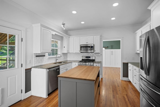 1204 Corlew Dr, Burns, TN 37029 - kitchen with stainless steel appliances, butcher block countertops, white cabinetry, tasteful backsplash, and plenty of natural light