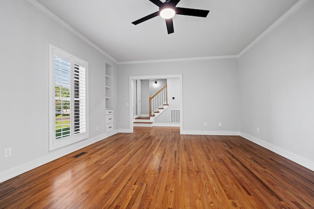 1204 Corlew Dr, Burns, TN 37029 - unfurnished room featuring built in features, a ceiling fan, crown molding, wood finished floors, and stairs