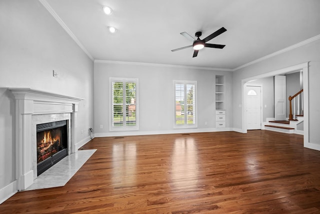 1204 Corlew Dr, Burns, TN 37029 - unfurnished living room with built in shelves, a fireplace, a ceiling fan, stairway, and wood finished floors