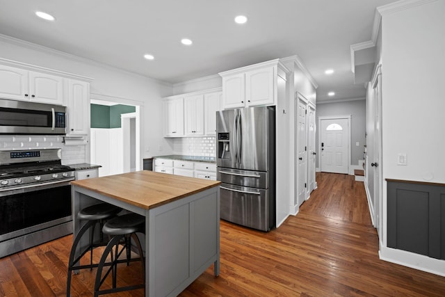 1204 Corlew Dr, Burns, TN 37029 - kitchen with appliances with stainless steel finishes, butcher block counters, ornamental molding, white cabinets, and backsplash