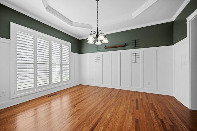 1204 Corlew Dr, Burns, TN 37029 - unfurnished dining area featuring a decorative wall, a chandelier, a raised ceiling, wood finished floors, and ornamental molding