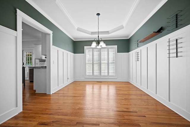 1204 Corlew Dr, Burns, TN 37029 - unfurnished dining area featuring a decorative wall, a raised ceiling, a chandelier, wood finished floors, and a wainscoted wall