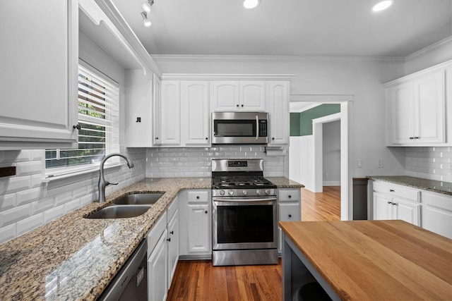 1204 Corlew Dr, Burns, TN 37029 - kitchen featuring stainless steel appliances, tasteful backsplash, white cabinets, light stone countertops, and crown molding