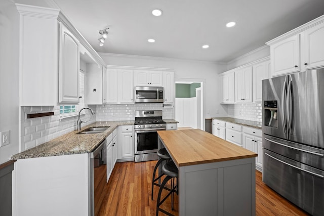 1204 Corlew Dr, Burns, TN 37029 - kitchen with stainless steel appliances, wooden counters, white cabinetry, recessed lighting, and ornamental molding