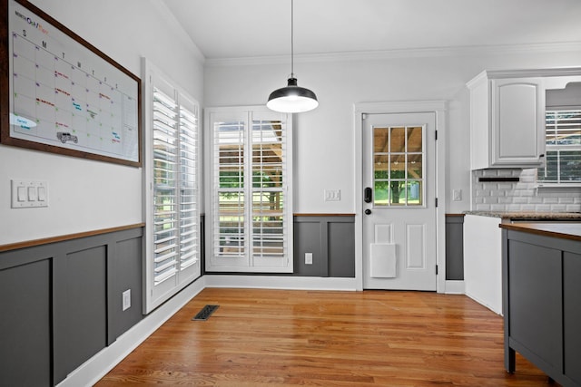 1204 Corlew Dr, Burns, TN 37029 - kitchen featuring crown molding, light wood-style floors, decorative light fixtures, white cabinetry, and backsplash