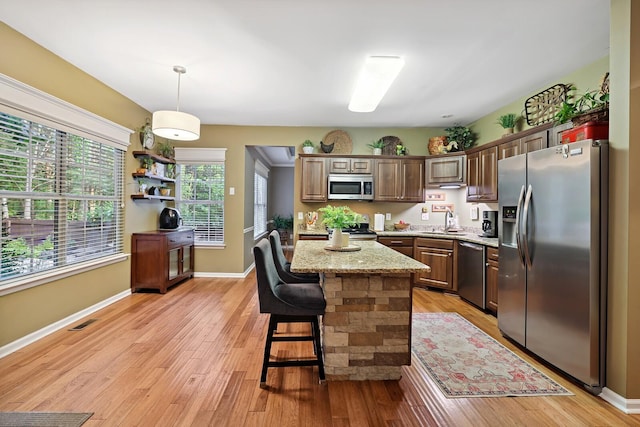 1511 Cardinal Ln, Mount Juliet, TN 37122 - kitchen with appliances with stainless steel finishes, a center island, light wood finished floors, and decorative light fixtures