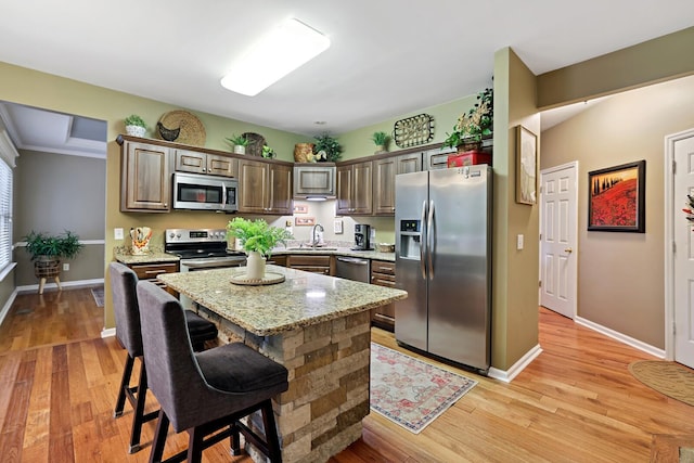 1511 Cardinal Ln, Mount Juliet, TN 37122 - kitchen featuring stainless steel appliances, light stone countertops, light wood-type flooring, and a center island