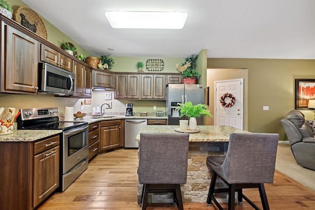 1511 Cardinal Ln, Mount Juliet, TN 37122 - kitchen with appliances with stainless steel finishes, a breakfast bar area, light wood-style flooring, and a kitchen island