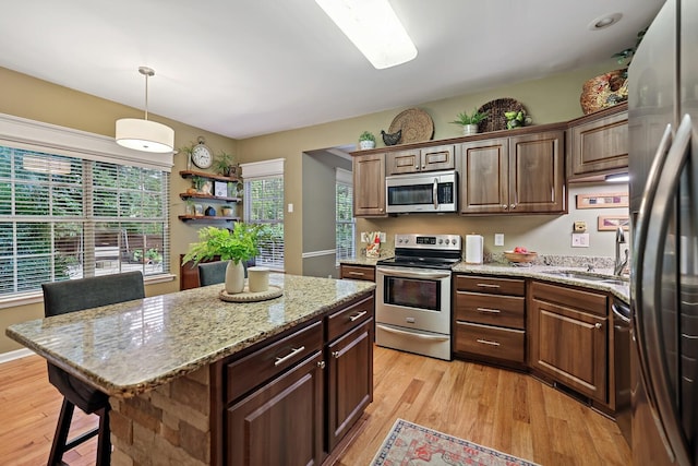 1511 Cardinal Ln, Mount Juliet, TN 37122 - kitchen featuring stainless steel appliances, light wood finished floors, a kitchen island, pendant lighting, and light stone countertops
