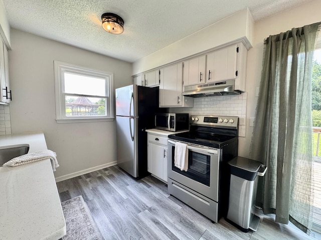 3409 Dutton Ct, Murfreesboro, TN 37130 - kitchen with appliances with stainless steel finishes, under cabinet range hood, decorative backsplash, a textured ceiling, and light countertops