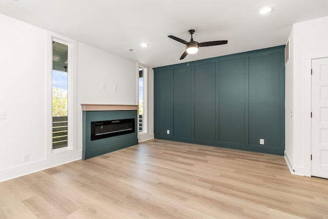 11 Dutch Dr, Clarksville, TN 37043 - unfurnished living room featuring a ceiling fan, light wood-style flooring, a glass covered fireplace, recessed lighting, and a decorative wall