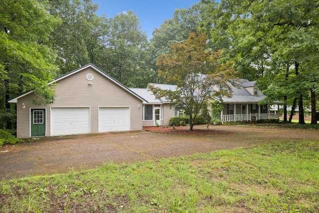 219 Lakeview Dr, Hohenwald, TN 38462 - view of front of home featuring driveway, a garage, a metal roof, a porch, and view of scattered trees