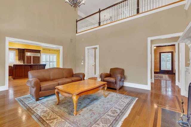 1512 Mirabella Way, Murfreesboro, TN 37130 - living room featuring light wood finished floors, a towering ceiling, ornamental molding, and a chandelier