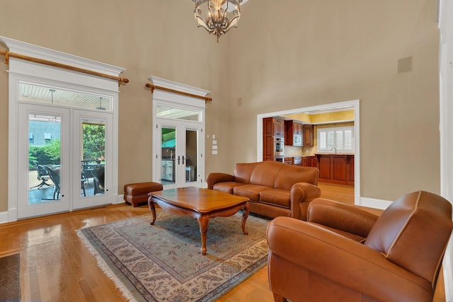 1512 Mirabella Way, Murfreesboro, TN 37130 - living area featuring french doors, a high ceiling, light wood-style flooring, a chandelier, and plenty of natural light