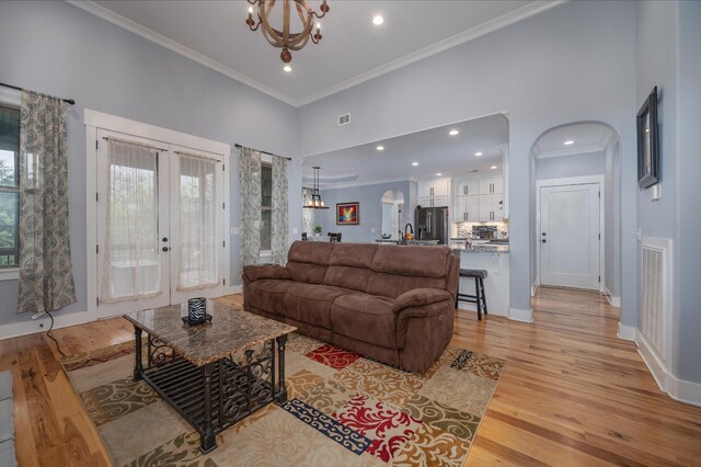 822 Manner Ln, Lebanon, TN 37087 - living area with arched walkways, a chandelier, a towering ceiling, ornamental molding, and light wood finished floors