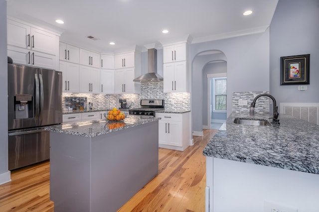 822 Manner Ln, Lebanon, TN 37087 - kitchen with stainless steel appliances, wall chimney exhaust hood, dark stone countertops, decorative backsplash, and arched walkways