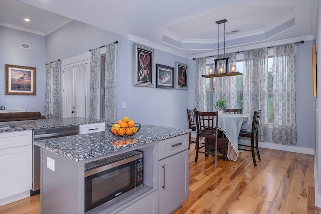 822 Manner Ln, Lebanon, TN 37087 - kitchen with appliances with stainless steel finishes, a chandelier, light stone countertops, a tray ceiling, and crown molding