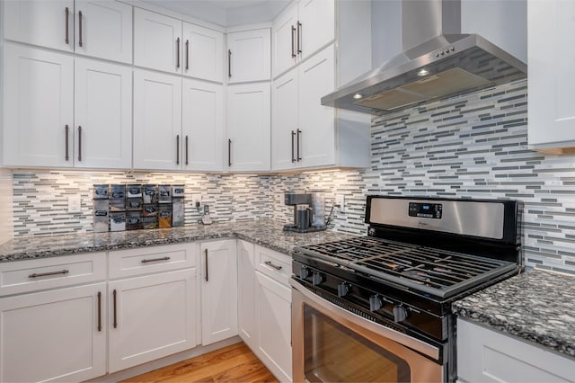 822 Manner Ln, Lebanon, TN 37087 - kitchen with gas range, wall chimney exhaust hood, white cabinetry, backsplash, and dark stone countertops