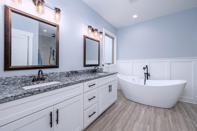 822 Manner Ln, Lebanon, TN 37087 - bathroom with double vanity, a decorative wall, a soaking tub, a tile shower, and wainscoting