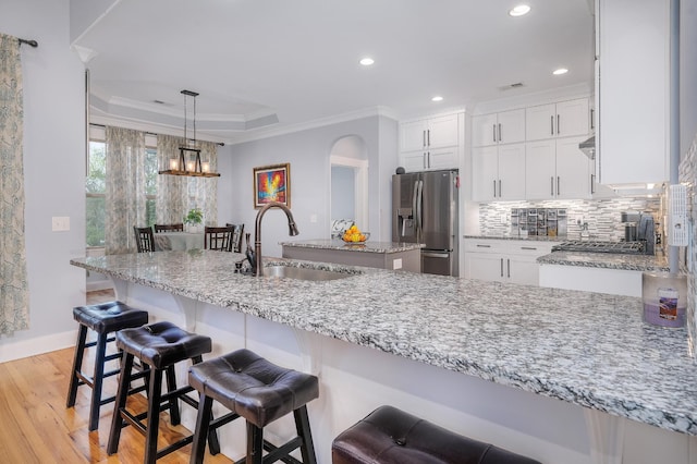 822 Manner Ln, Lebanon, TN 37087 - kitchen featuring stainless steel refrigerator with ice dispenser, light wood-style floors, a tray ceiling, white cabinetry, and crown molding