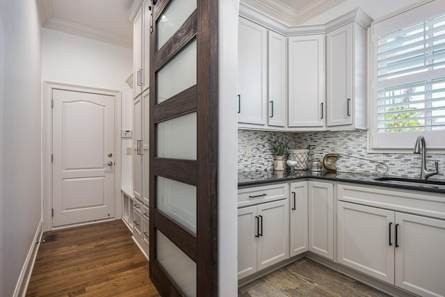 7216 Wildings Blvd, College Grove, TN 37046 - kitchen featuring crown molding, decorative backsplash, dark wood-style flooring, and white cabinetry