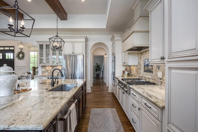 7216 Wildings Blvd, College Grove, TN 37046 - kitchen with a chandelier, arched walkways, stainless steel appliances, a spacious island, and decorative backsplash