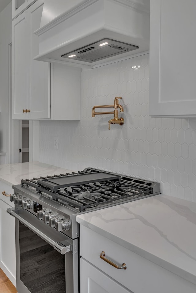 1117 38th Ave N Unit B, Nashville, TN 37209 - kitchen with high end stainless steel range, custom exhaust hood, backsplash, and white cabinetry