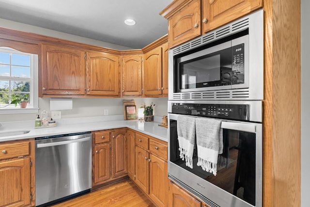 3406 Parks Ln, Spring Hill, TN 37174 - kitchen featuring appliances with stainless steel finishes, light countertops, light wood finished floors, and brown cabinetry