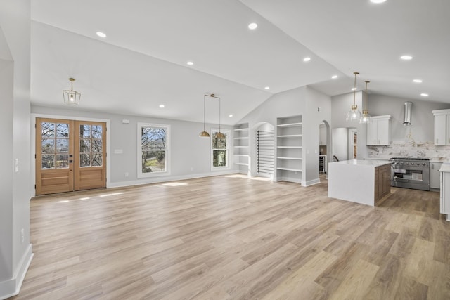 6608 Brookmont Ter, Nashville, TN 37205 - unfurnished living room featuring vaulted ceiling, built in shelves, arched walkways, light wood-style floors, and recessed lighting