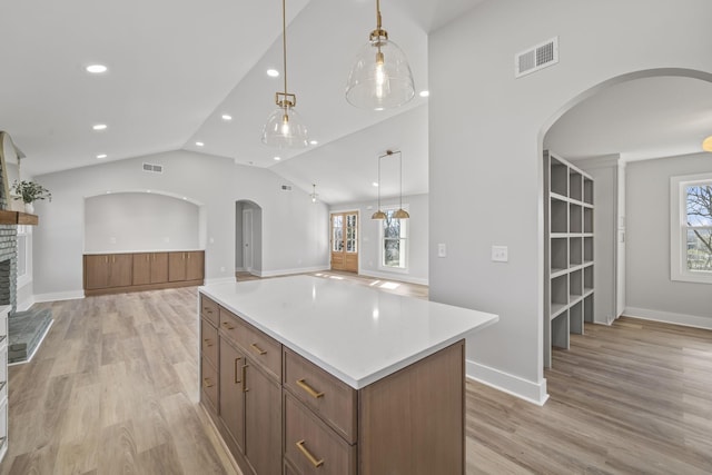 6608 Brookmont Ter, Nashville, TN 37205 - kitchen featuring arched walkways, open floor plan, a center island, vaulted ceiling, and light wood-style floors