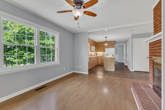 5347 Shady Grove Rd, Morrison, TN 37357 - unfurnished living room featuring a brick fireplace, dark wood-type flooring, ceiling fan, and a textured ceiling
