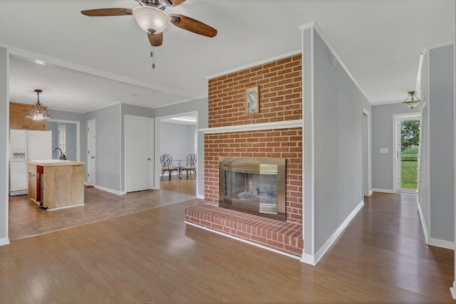 5347 Shady Grove Rd, Morrison, TN 37357 - unfurnished living room featuring wood finished floors, ceiling fan, a fireplace, and crown molding