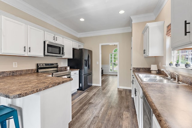 4061 Locerbie Cir, Spring Hill, TN 37174 - kitchen featuring stainless steel appliances, dark wood-style floors, white cabinetry, crown molding, and recessed lighting