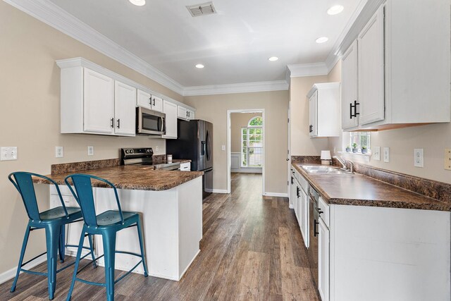 4061 Locerbie Cir, Spring Hill, TN 37174 - kitchen featuring stainless steel appliances, dark countertops, dark wood-style flooring, crown molding, and recessed lighting