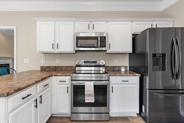 4061 Locerbie Cir, Spring Hill, TN 37174 - kitchen featuring appliances with stainless steel finishes, ornamental molding, dark countertops, white cabinets, and a peninsula