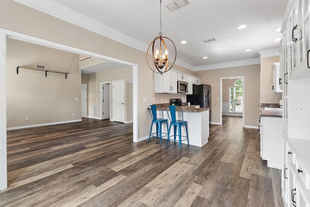 4061 Locerbie Cir, Spring Hill, TN 37174 - kitchen featuring stainless steel microwave, ornamental molding, dark wood-style flooring, a peninsula, and white cabinetry