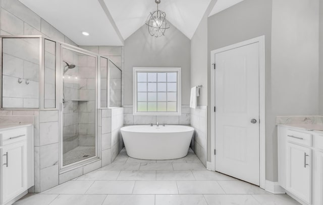 329 Clarabelle Ln, Clarksville, TN 37040 - bathroom featuring vaulted ceiling, vanity, a stall shower, a freestanding bath, and tile walls
