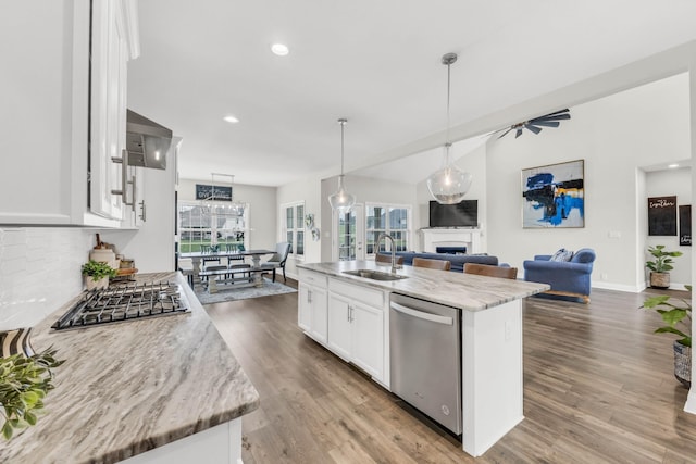 329 Clarabelle Ln, Clarksville, TN 37040 - kitchen featuring appliances with stainless steel finishes, a fireplace, open floor plan, white cabinets, and wall chimney exhaust hood