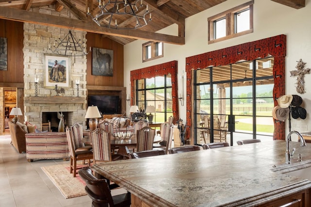 6971 W Cove Rd, Chickamauga, GA 30707 - dining area with high vaulted ceiling, a wood ceiling with exposed beams, a stone fireplace, plenty of natural light, and a chandelier